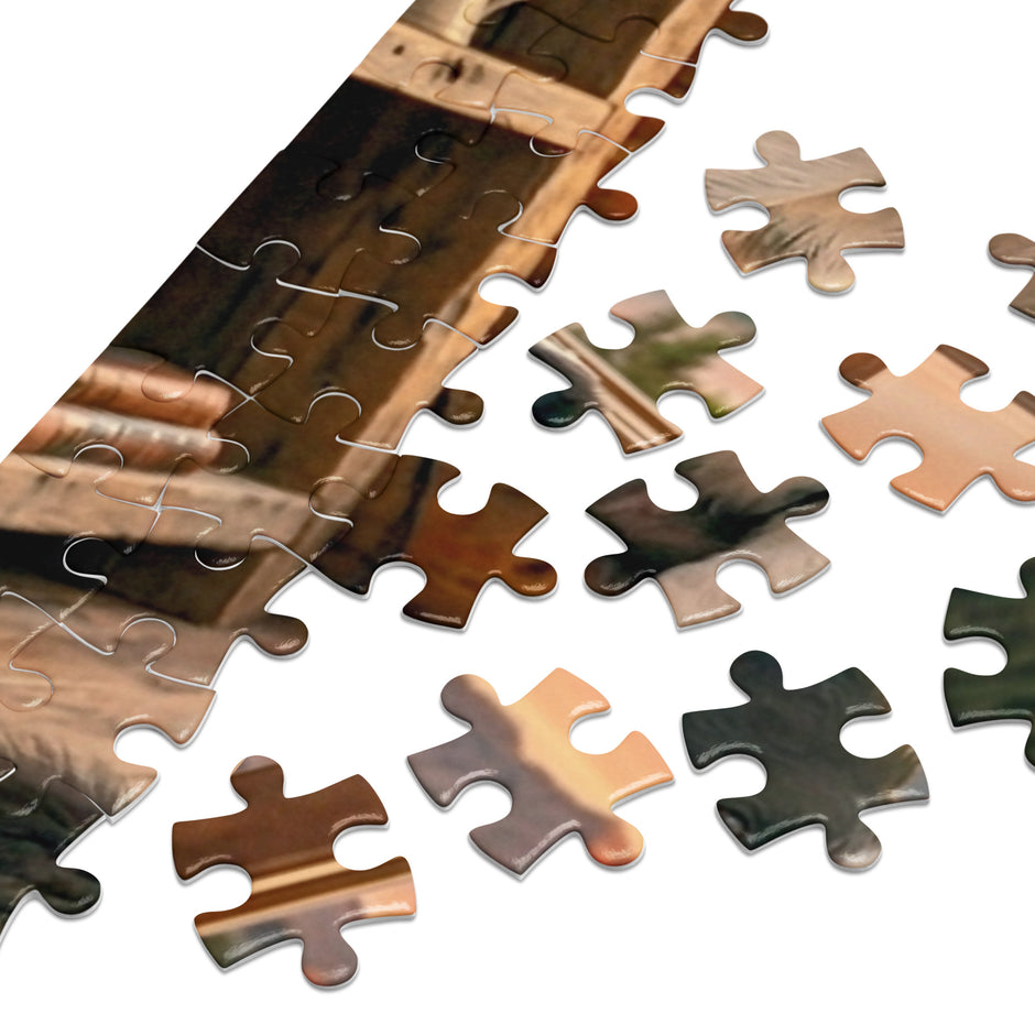 Border Collie Family Cabin Jigsaw Puzzle in Tin showing scattered pieces and wooden cabin scene.