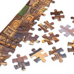 Close-up of the Cat City Life Jigsaw Puzzle in Tin pieces spread out, showcasing detailed urban feline illustrations.