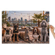Pug, German Shepherd, Whippet, Basset Hound & Poodle Jigsaw Puzzle in Tin featuring dogs on a rooftop at sunset with city skyline.