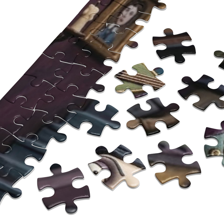Close-up of Gothic Angel Music Room Jigsaw Puzzle in Tin pieces on a white surface.
