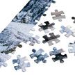 Close-up of Husky Family Winter Jigsaw Puzzle in Tin with puzzle pieces and snowy mountain design