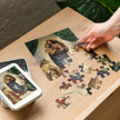 Sistine Madonna by Raphael Puzzle in Tin showcased on a table with scattered pieces and a metal box featuring the artwork.